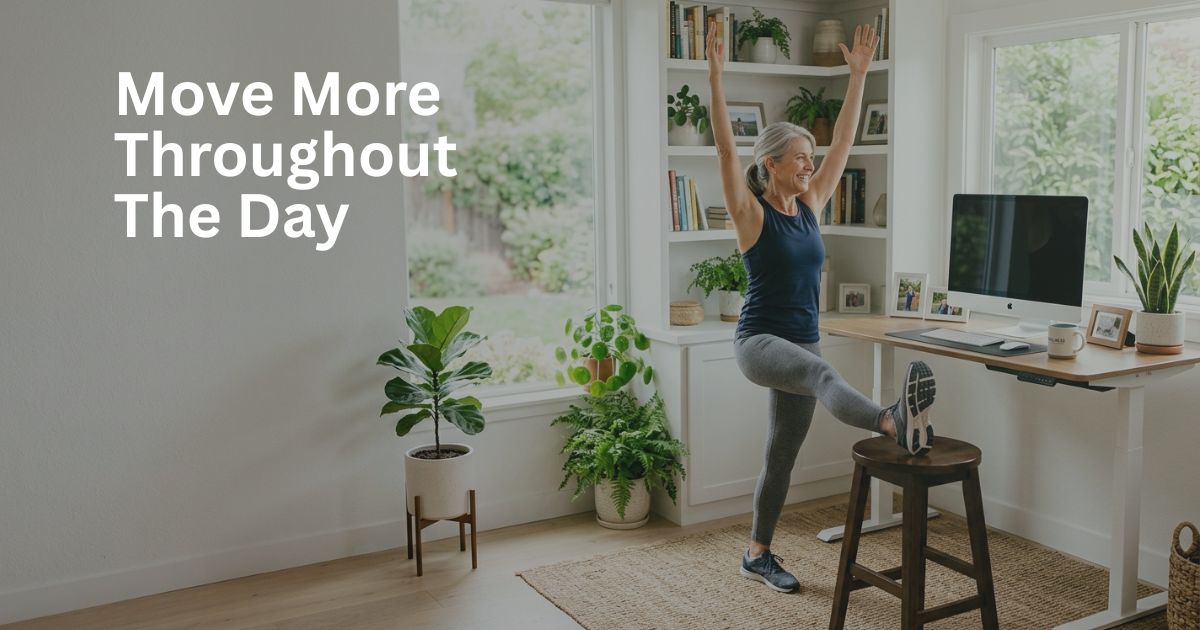 Article-38-move-more-throughout-the-day-2 Woman over 50 standing and stretching beside her desk to reduce sitting time and support metabolic health.